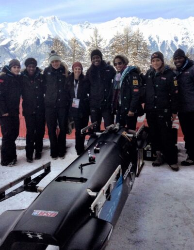 Dr. Mar and USA Bobsled Women's team in Germany - Mountains in background - sled in center