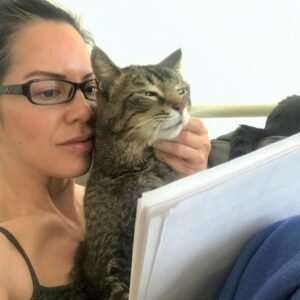 Dr. Mar reading research with her cat