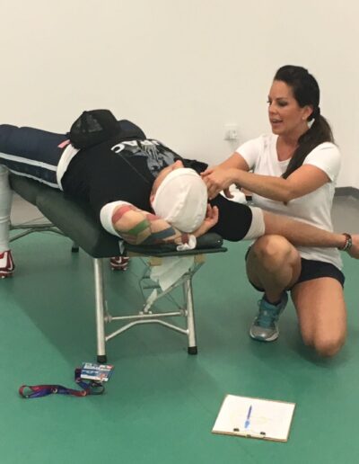 Chiropractor Dr Mindy Mar adjusting USA Football player on a table